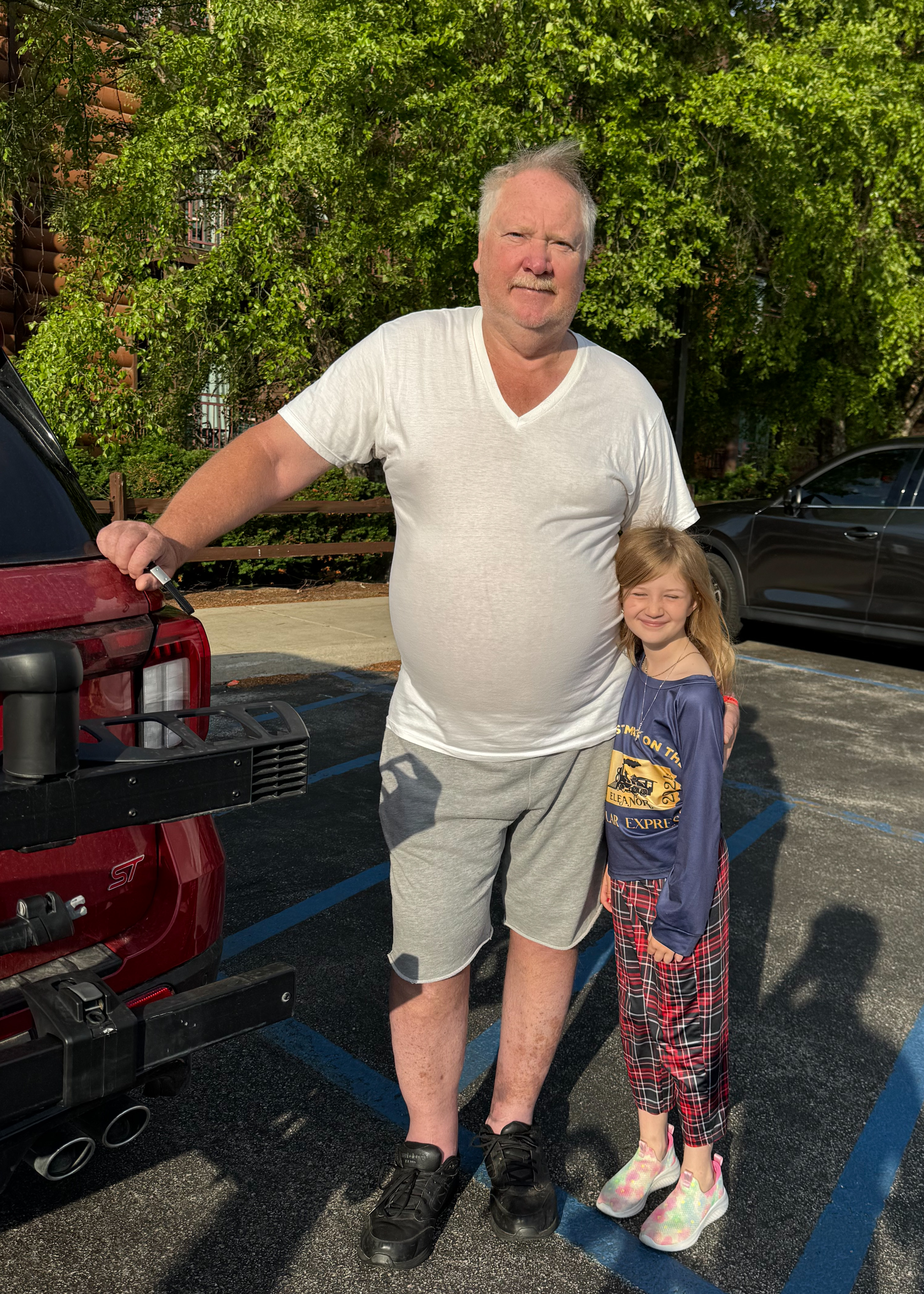 Family supporters standing together in a parking lot at the start of the day.