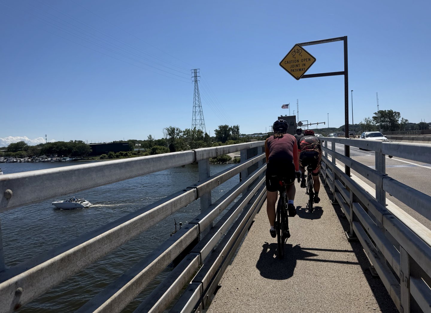 A cyclist crossing a bridge beside a water channel.