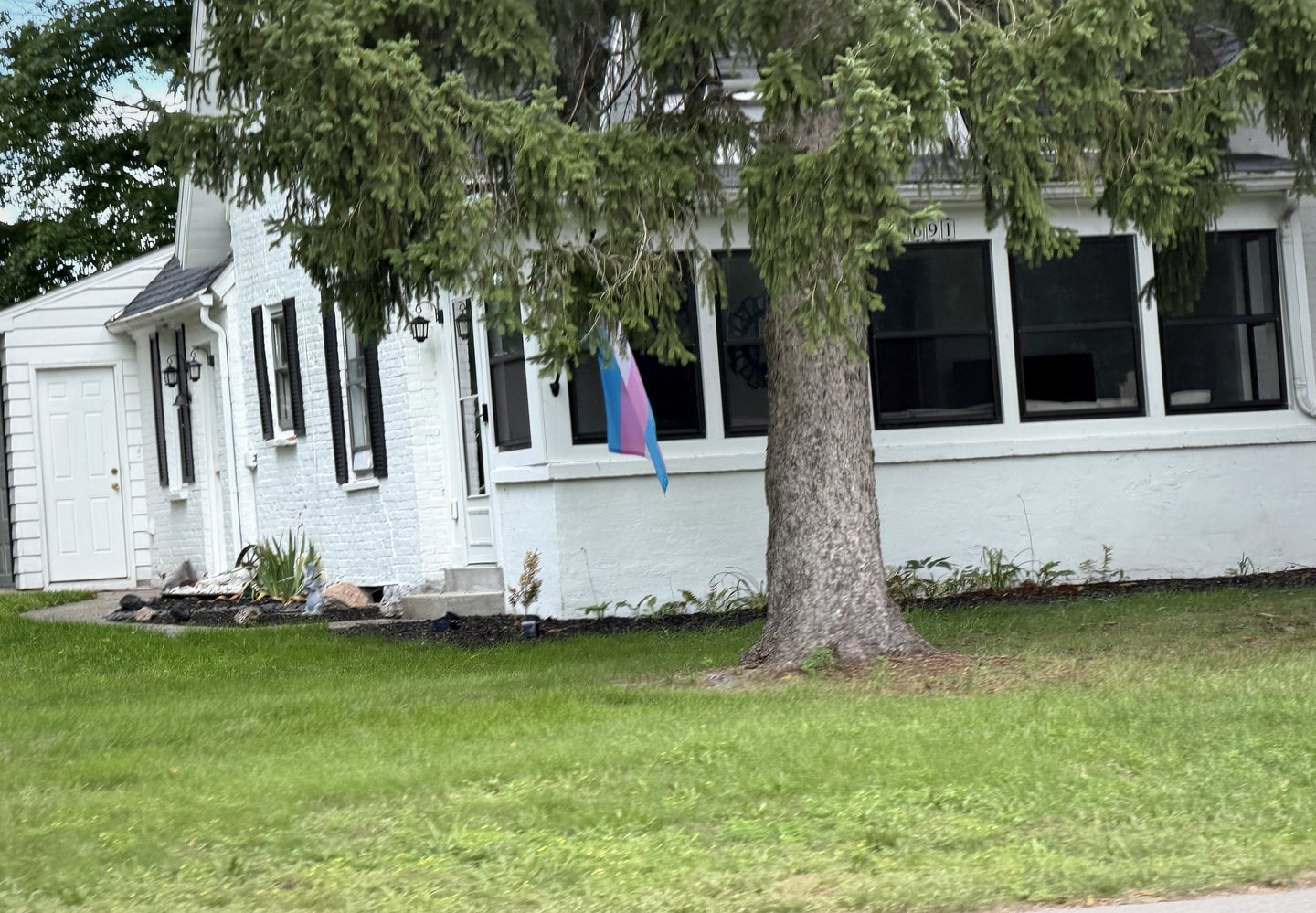A Pride flag displayed on a white home in East Grand Rapids.