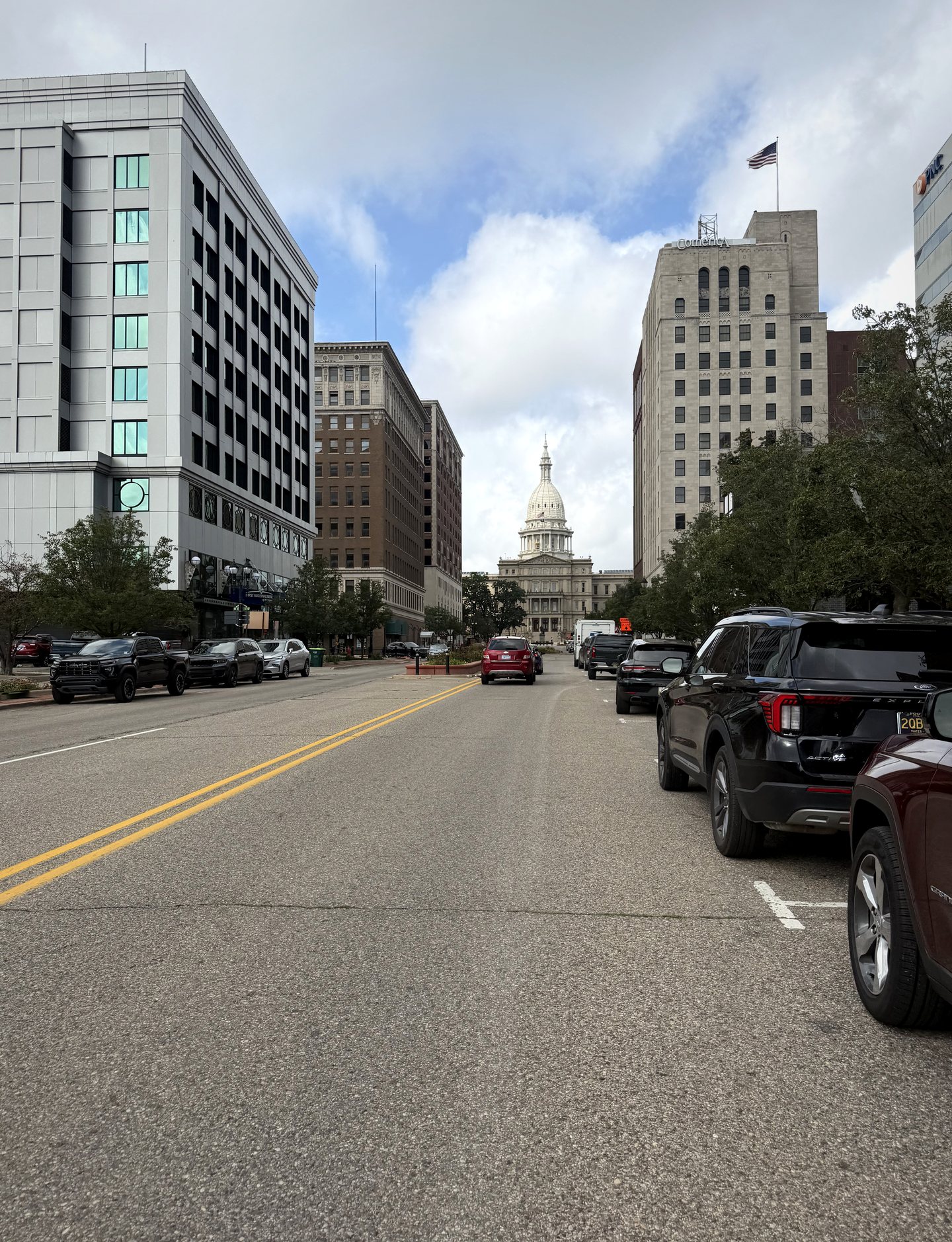 The Michigan State Capitol visible at the end of a downtown Lansing street.