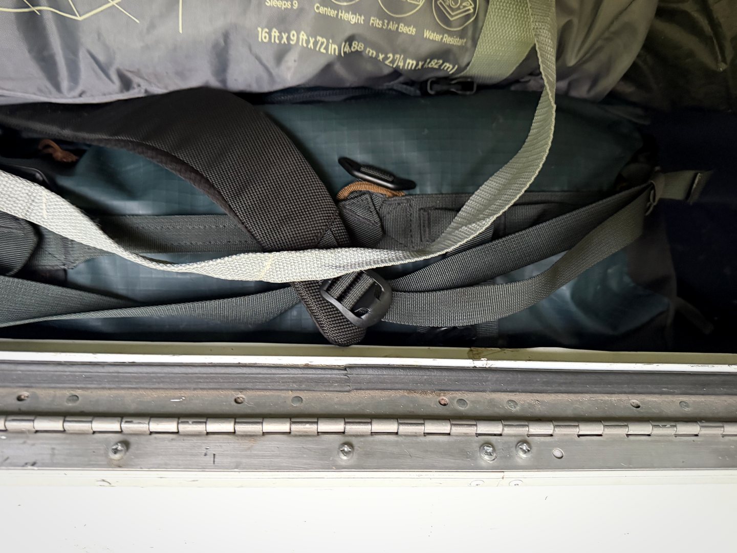 Camping gear packed tightly inside an RV storage compartment.
