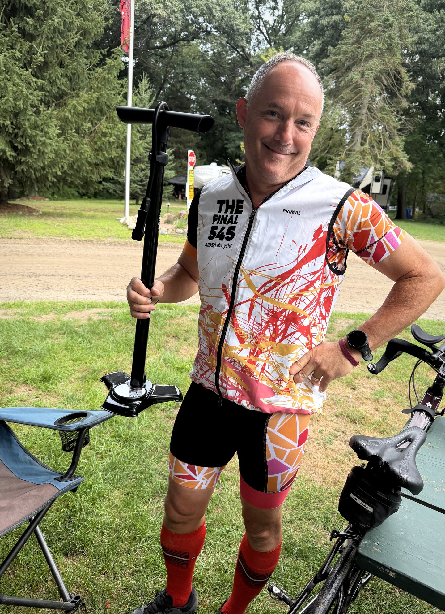 A rider using a floor pump beside a bicycle before the final day.