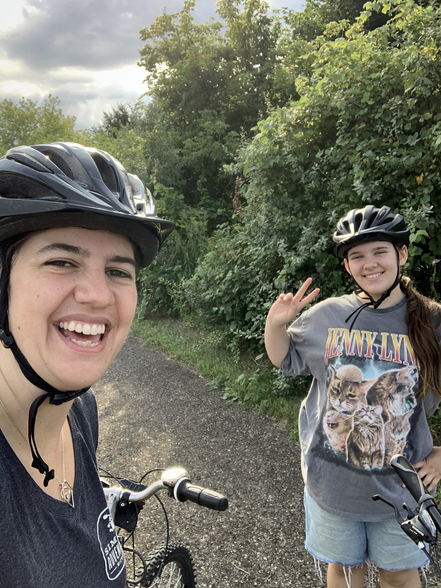 A cyclist and a young one-day rider smiling for a trail selfie.