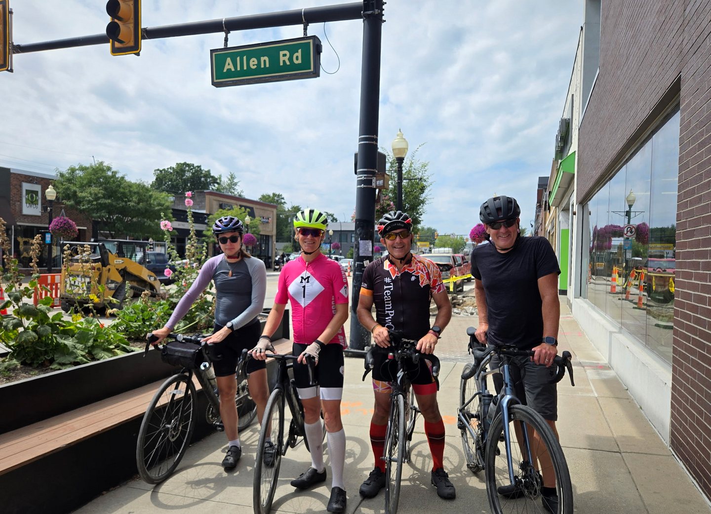 Four riders standing with their bicycles near 9 Mile Road in Ferndale.